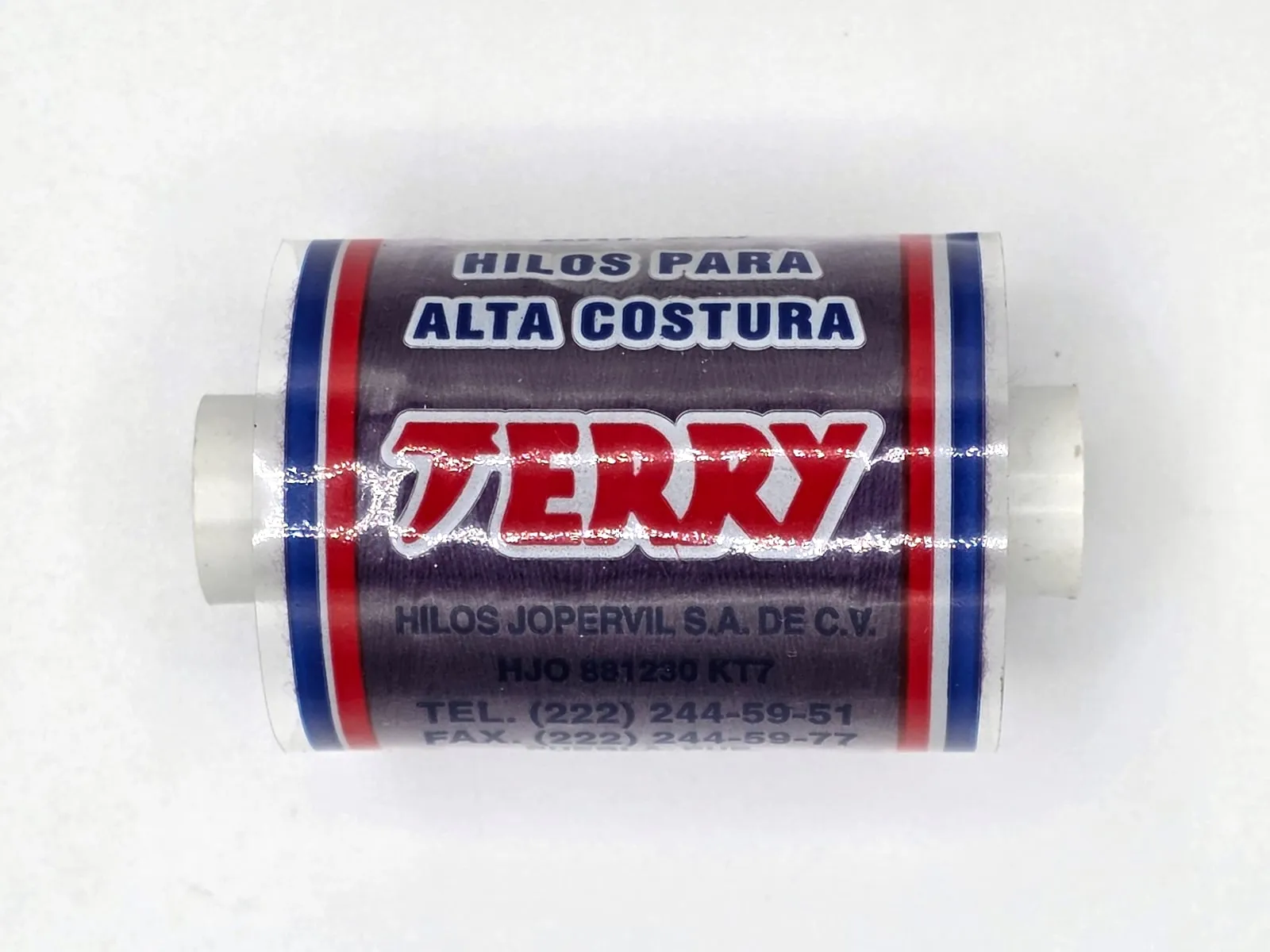 Tubo de hilo Terry morado, acostado, con su etiqueta «Hilos para alta costura».