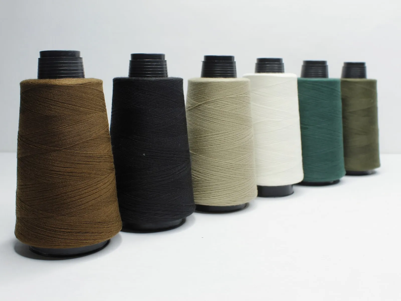 Seis conos de hilo Terry en café, negro, caqui, blanco, verde y olivo.