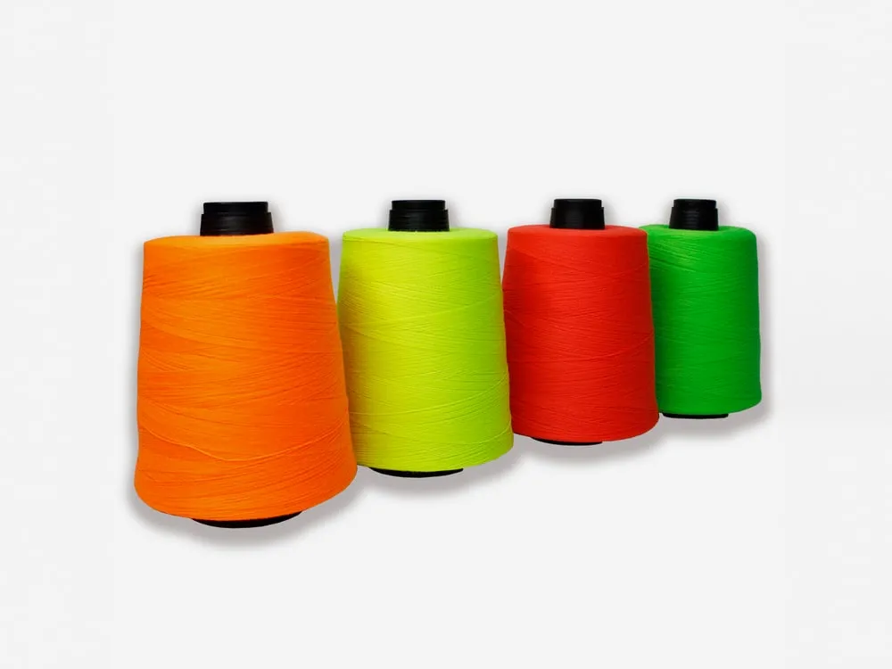 Cuatro conos del Art. 5000 de hilo Terry en colores fosforescentes: naranja, amarillo, rojo y verde.