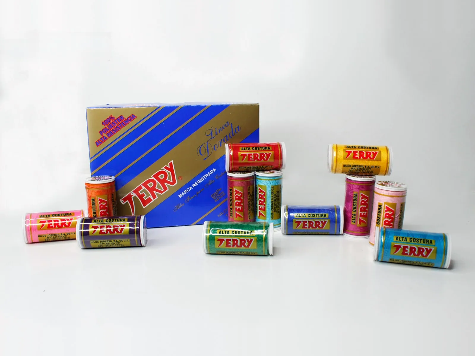 La caja de la Línea Dorada de hilo Terry, con sus tubos de colores alrededor.