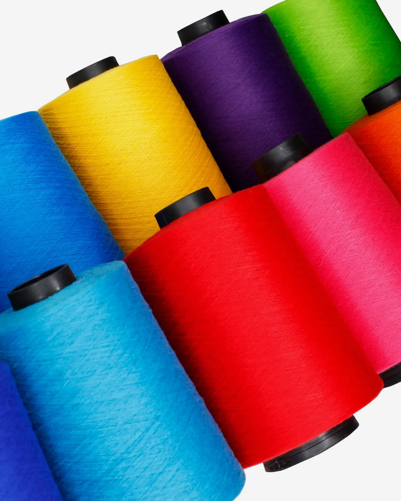 Conos industriales de hilo Terry en verde, azul, amarillo, morado, rojo, rosa y naranja.