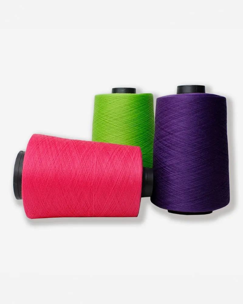 Tres conos industriales de hilo Terry: rosa, verde y morado.